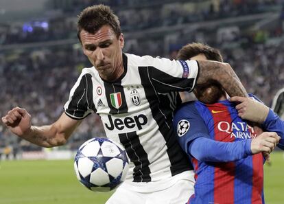 Mario Mandzukic (i) del Juventus, compite por el balón con Lionel Messi (d) del Barcelona.