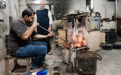 El soplador de vidrios Bachar Jalil trabajando junto a Mohamed el Jalak en la f&aacute;brica Beit el Azaz de Damasco.