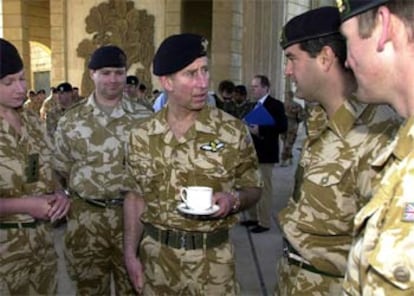 El Príncipe de Gales toma una taza de té mientras charla con varios soldados en el palacio de Al Sarraji, en Basora.