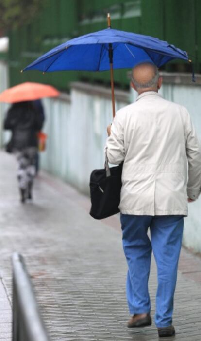 Un hombre camina este jueves la lluvia en Madrid