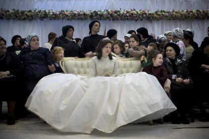A Jewish bride sits with family members in the women's section during her wedding to the grandson of the Rabbi of the Tzanz Hasidic dynasty community, in Netanya, Israel, Tuesday, March 15, 2016. (AP Photo/Oded Balilty) 
