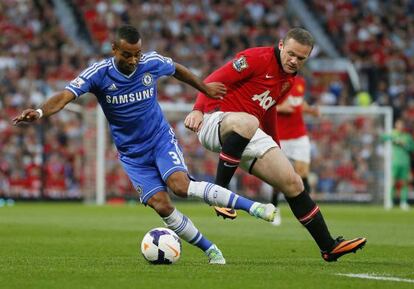 Cole y Rooney se disputan el balón.