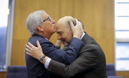 El presidente de la Comisión Europea, Jean-Claude Juncker (izquierda), besa en la frente al comisario europeo de Asuntos Económicos, Pierre Moscovici
