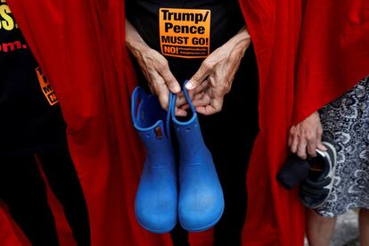Activistas vestidas como mujeres destinadas a la reproducción de la serie 'The Handmaid's Tale' depositan zapatos y ropa de niños inmigrantes separados de sus padres, en Manhattan (Estados Unidos), el 31 de julio de 2018.