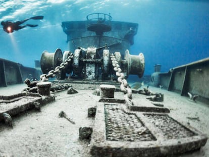 Un buzo, sobre un barco hundido en aguas de las Islas Caimán.