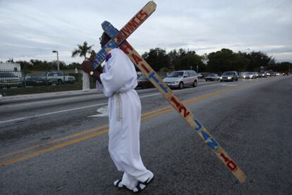 La conmemoración del aniversario de la tragedia de Haití fue secundada en otros puntos del planeta. En la imagen, un hombre porta una cruz en la que se recuerda la fatídica fecha, en Miami (Florida).