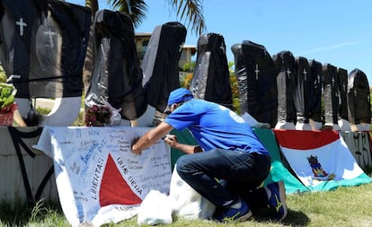 Cada uma das letras do letreiro da cidade foi envolta por um saco preto de lixo e um sinal de cruz em homenagem às vítimas da tragédia. 