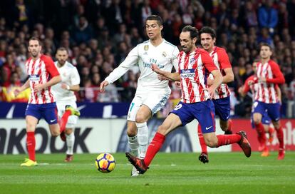 Juanfran (derecha), del Atlético de Madrid, y Cristiano Ronaldo, corren por hacerse con el balón.