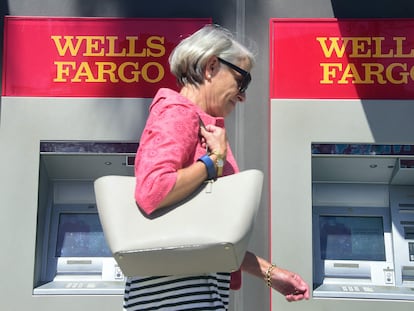 Una mujer pasa delante de dos cajeros automáticos de Wells Fargo en Pasadena (California), en una imagen de archivo.