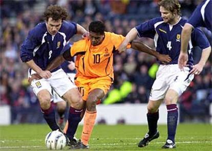 Los escoceses Dailly y Pressley sujetan a Kluivert  en el partido.