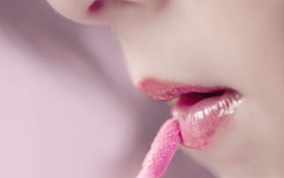 Una niña se pinta los labios.
