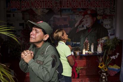 Dos mujeres lloran durante su visita a la capilla del presidente Hugo Chávez en su mausoleo en Caracas, al cumplirse un año de la muerte del presidente.