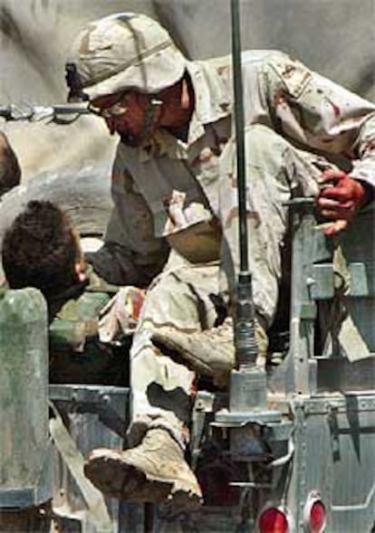 Un militar de EE UU habla con un colega herido camino de un hospital de Bagdad.