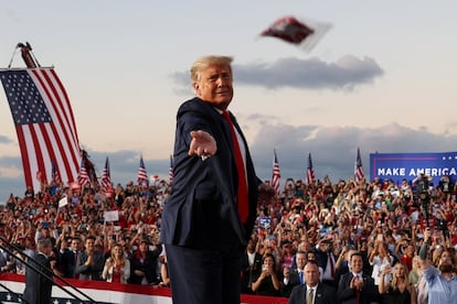 Trump arroja mascarillas a la multitud mientras sube al escenario para dar el mitin electoral.