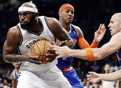 Reggie Evans, de los Nets, se lleva el balón ante Jason Kidd y Carmelo Anthony, de los Knicks