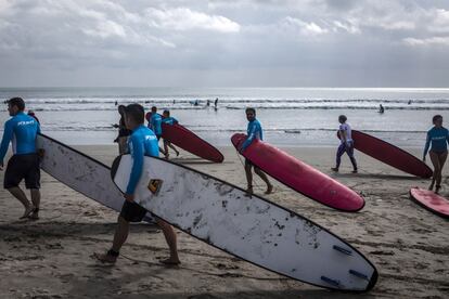 Varios turistas con sus tablas de surf en una playa de Kuta, en Bali (Indonesia).