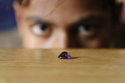Uno de los niños rescatados de un taller de Jaipur contempla una gema.