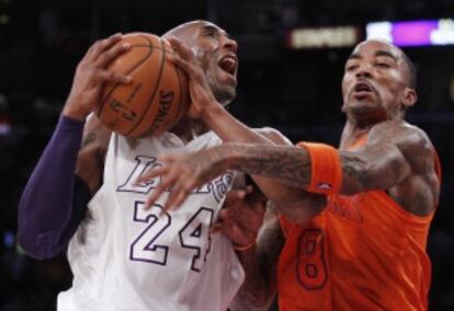 J.R. Smith trata de frenar un avance de Bryant.