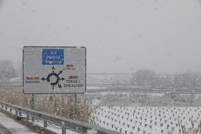 Vista de los campos cercanos a la localidad de Utiel cubiertos por la nieve que cae desde esta mañana.