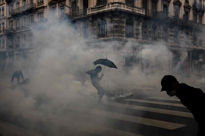 Manifestantes entre nubes de gas durante el Primero de Mayo en Lyon. 