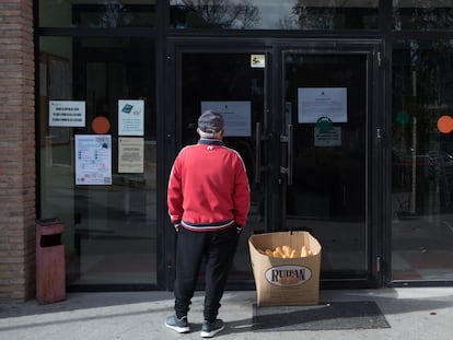 Un jubilado lee la nota informativa que explica el cierre del Centro Municipal de Mayores de Valdemoro (Madrid).