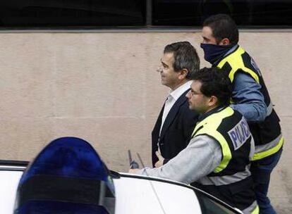 Dos policías nacionales conducen a Ginés Jiménez a la sede de la Policía Local de Coslada el jueves.