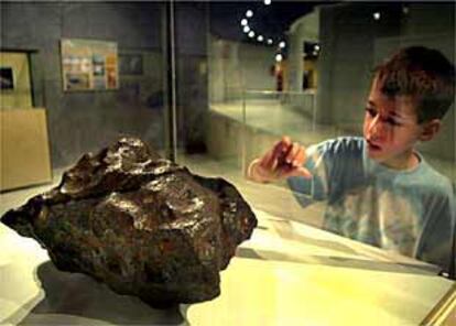 Un niño observa, ayer, uno de los meteoritos expuestos en Castellón.