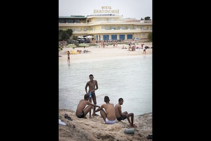 Un grupo de inmigrantes se baña en la playa de Guitgia junto a los últimos turistas del verano –todos italianos— .