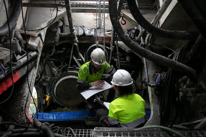 Dos operarios preparan los parámetros de excavación de la tuneladora de la L9 de Barcelona, en la cámara de tierras que hay a continuación de la rueda de cortes. Un espacio en el que, cuando se trabaja a mucha presión, solo acceden buzos.