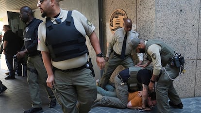 Las fuerzas del orden detienen a un manifestante en la Oficina Federal de Prisiones del Departamento de Justicia de EE UU tras un operativo.