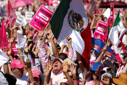 Manifestantes levantan pancartas y ondean banderas nacionales, durante la congregación de este domingo en el Zócalo capitalino.