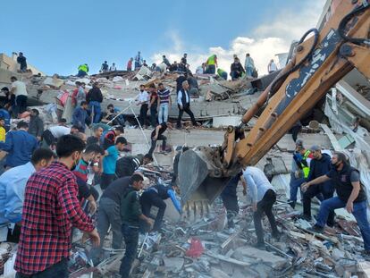 Los servicios de emergencia, con la ayuda de voluntarios civiles, buscan a los supervivientes del terremoto entre los escombros de un edificio, en la ciudad turca de Esmirna.