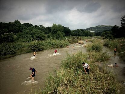 Un grupo de inmigrantes centroamericanos toman un baño en el río lagarteros de Chiapas.