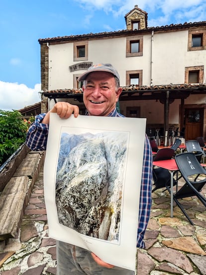Miguel Ángel campos, dueño de La Taberna de Tresviso, con el póster del camino de Urdón a Tresviso.