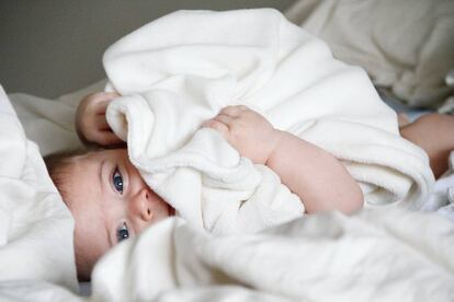 Un bebé tumbado en la cama. 