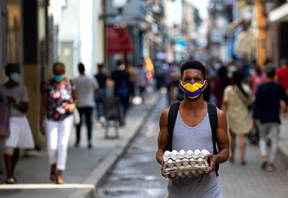 Cuba, la Habana hombre camina llevando un cartón de huevos