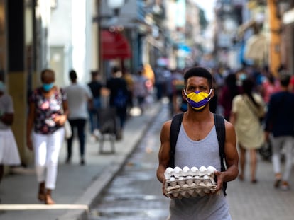 Un hombre camina llevando un cartón de huevos por la calle Obispo, en La Habana, el jueves 27 de enero del 2022.