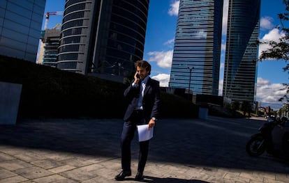 Un hombre camina por la zona la de las cuatro torres del paseo de la Castellana, en Madrid.