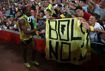 Bolt saluda a un aficionado con una pancarta a su nombre