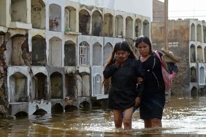 Mujeres caminan por un cementerio inundado, en Tucume, a 700 km al norte de Lima (Perú). Las lluvias torrenciales y desbordamientos de ríos han causado la muerte de 25 personas y han afectado a más de 200.000 en lo que llevamos de año.