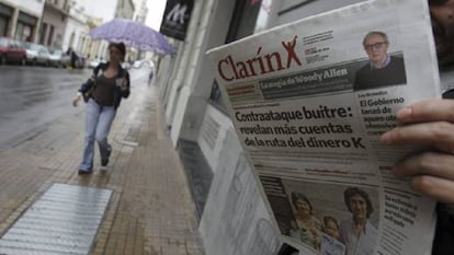 Un hombre lee un ejemplar del diario Clarín en una calle de Buenos Aires.