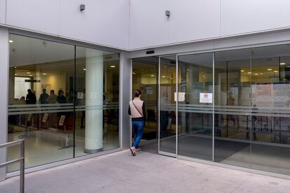 Una mujer entra en un centro de salud en el centro de Sevilla, donde varios pacientes guardan copla en su interior.