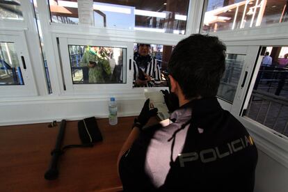 Un policia nacional verifica la identidad de una ciudadana marroquí en el puesto fronterizo entre España y Marruecos.