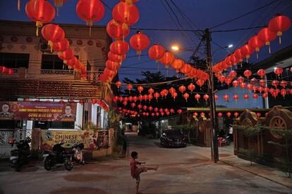 Un niño juega bajo los faroles que decoran el templo Hok Lay Kiong en la noche del Año Nuevo chino, en Bekasi (Indonesia). Personas de toda Asia se prepararon el lunes para las celebraciones del Año Nuevo Lunar.