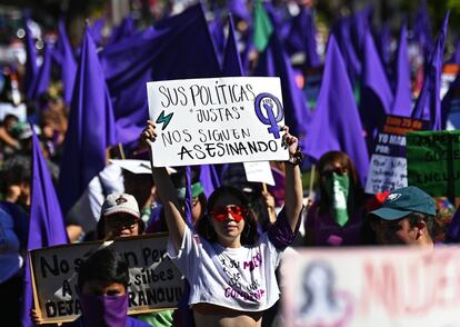 Una manifestante sostiene un cartel que dice "Sus políticas justas todavía nos están matando" durante una marcha en memoria da las mujeres asesinadas en El Salvador durante los actos celebrados en San Salvador en el Día Internacional para la Eliminación de la Violencia contra las Mujeres.