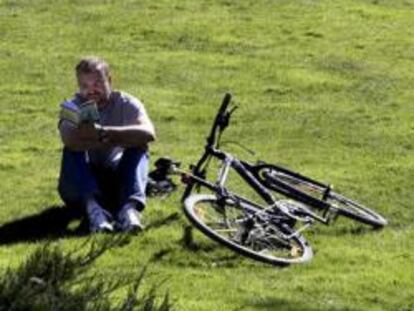 Un hombre disfruta del buen tiempo en una pradera del madrileño Paseo del Prado, durante el último día de invierno