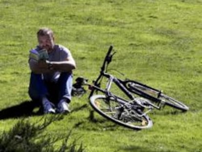 Un hombre disfruta del buen tiempo en una pradera del madrileño Paseo del Prado, durante el último día de invierno