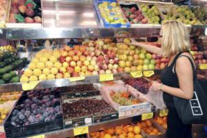 Una mujer adquiere fruta en un establecimiento. EFE/Archivo