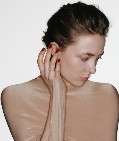 Vestido de manga murciélago de ALAÏA y anillo de oro rosa y diamantes de MESSIKA.