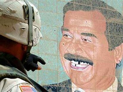 Un soldado observa un retrato de Sadam.